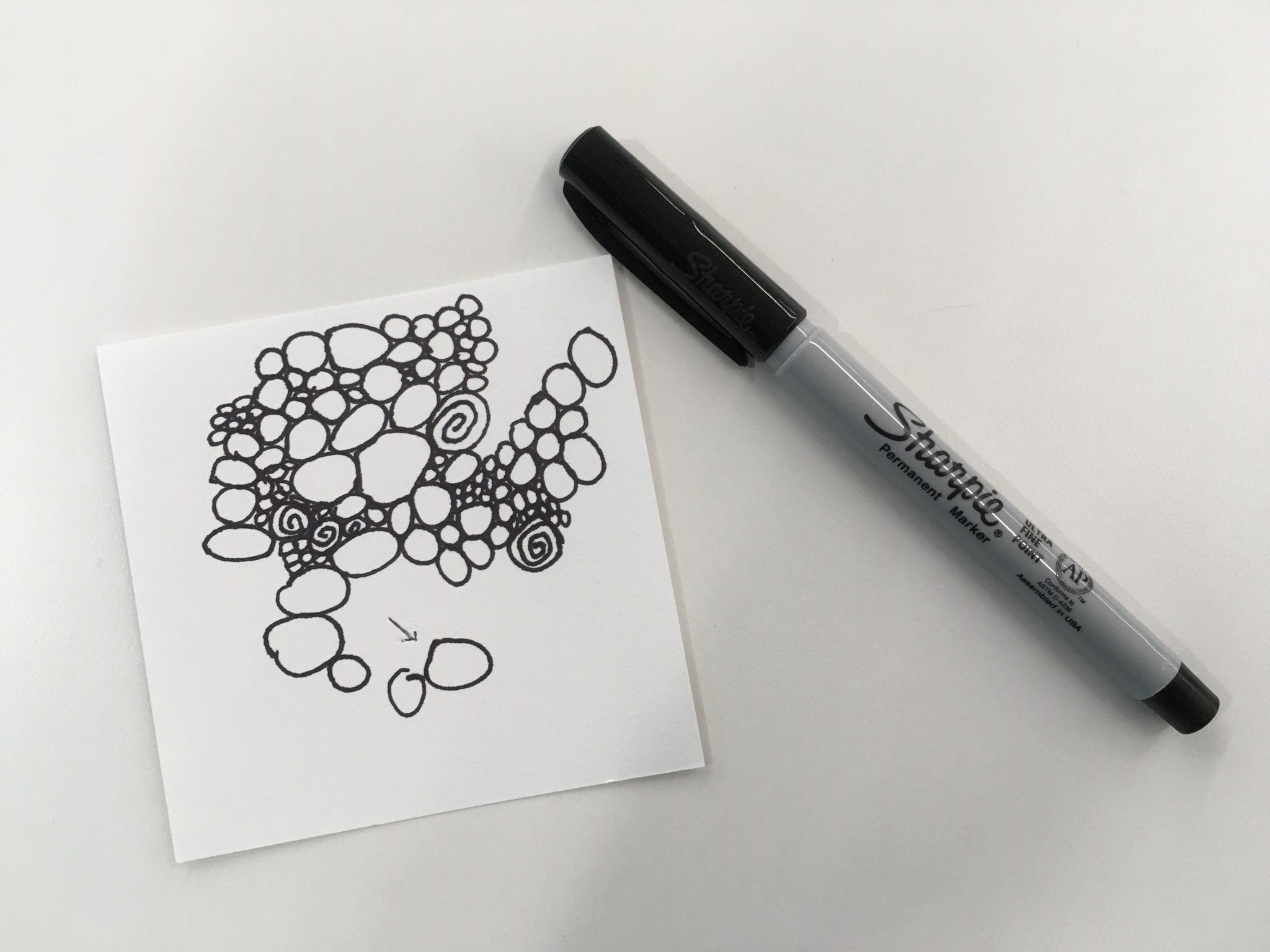 Paper square with more random circles in black ink.