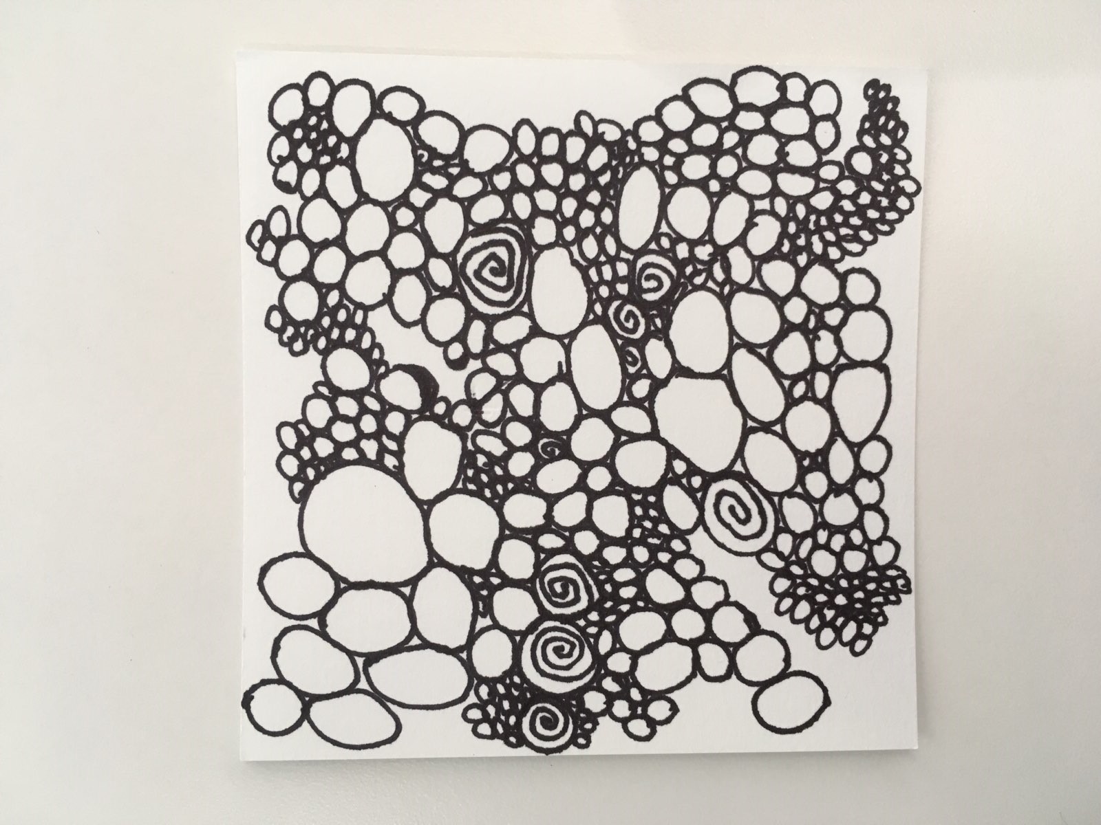 Paper square filled with randomly shaped and placed circles drawn with blank ink lines.